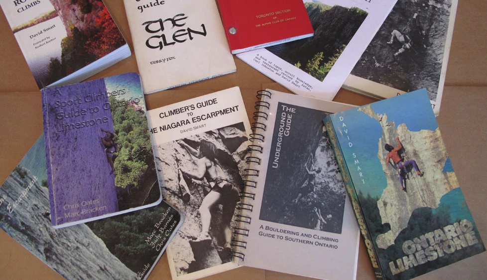 A selection of Canadian climbing guidebooks spread on a table