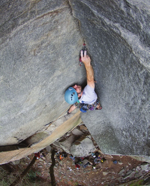 A climber bridging a steep granite corner system