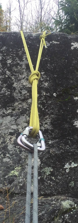 Un relais en sangle jaune sur un bloc, réuni sur un mousqueton à vis